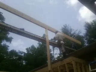 Carpenter setting a ridge beam over a new addition frame — Ice Dam Removal by Roofing Brothers in Tendoy