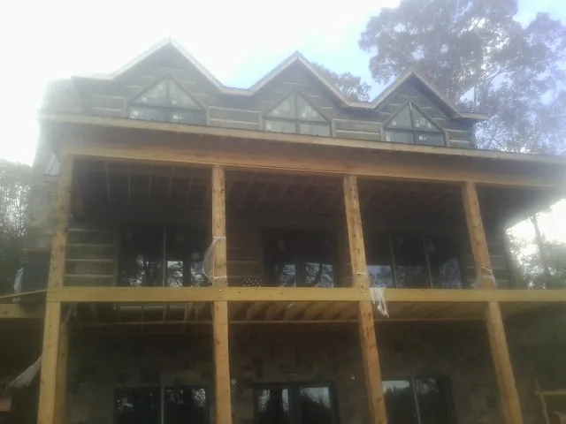 Dormers and porch framing on a large log home under construction — Roof Coating work by our crew in Tendoy