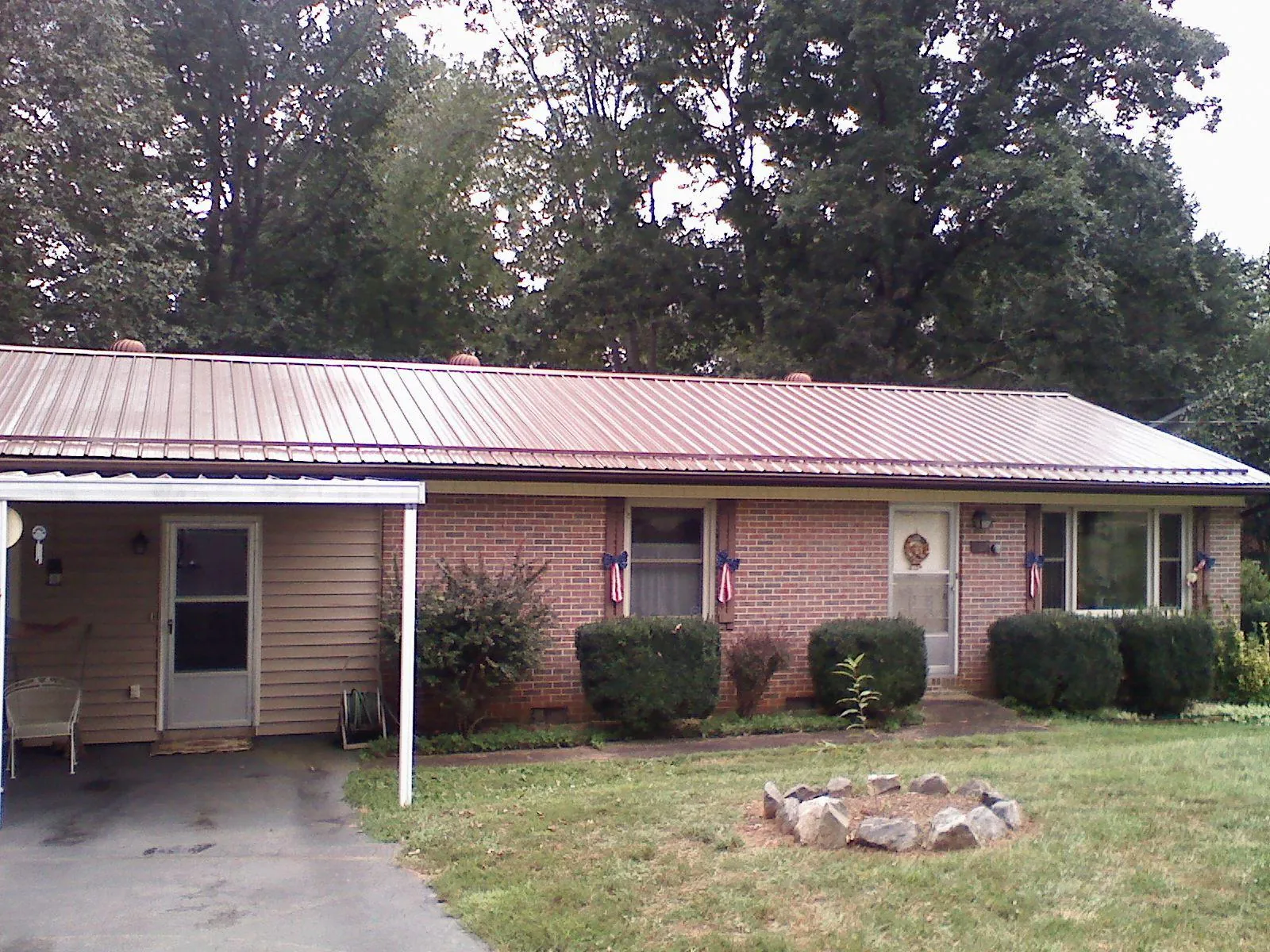 Bronze metal roof and carport on a brick ranch home — Roof Repair work by our crew in Tendoy